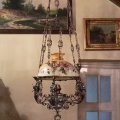 Three-arm petroleum lamp with one central light, the arms are decorated with musicians with cither, lampshade is hand-painted. 